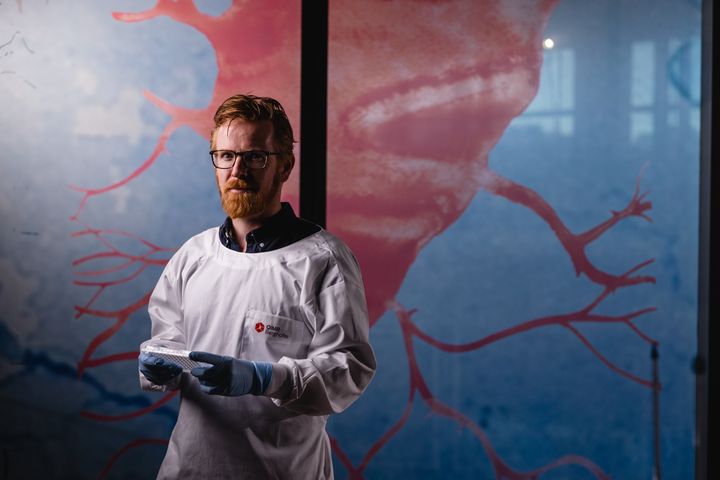 A scientist stares into the camera