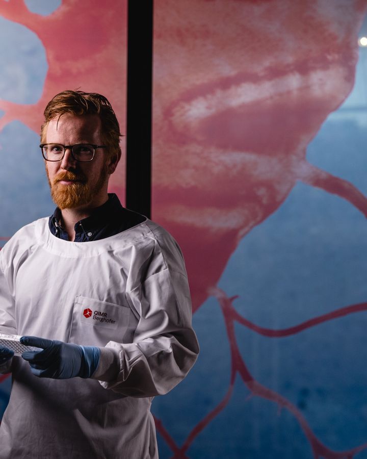 A scientist stares into the camera